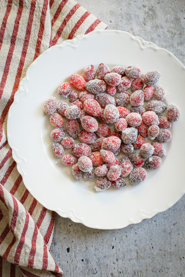 close up photo of a white plate with candied cranberries on it