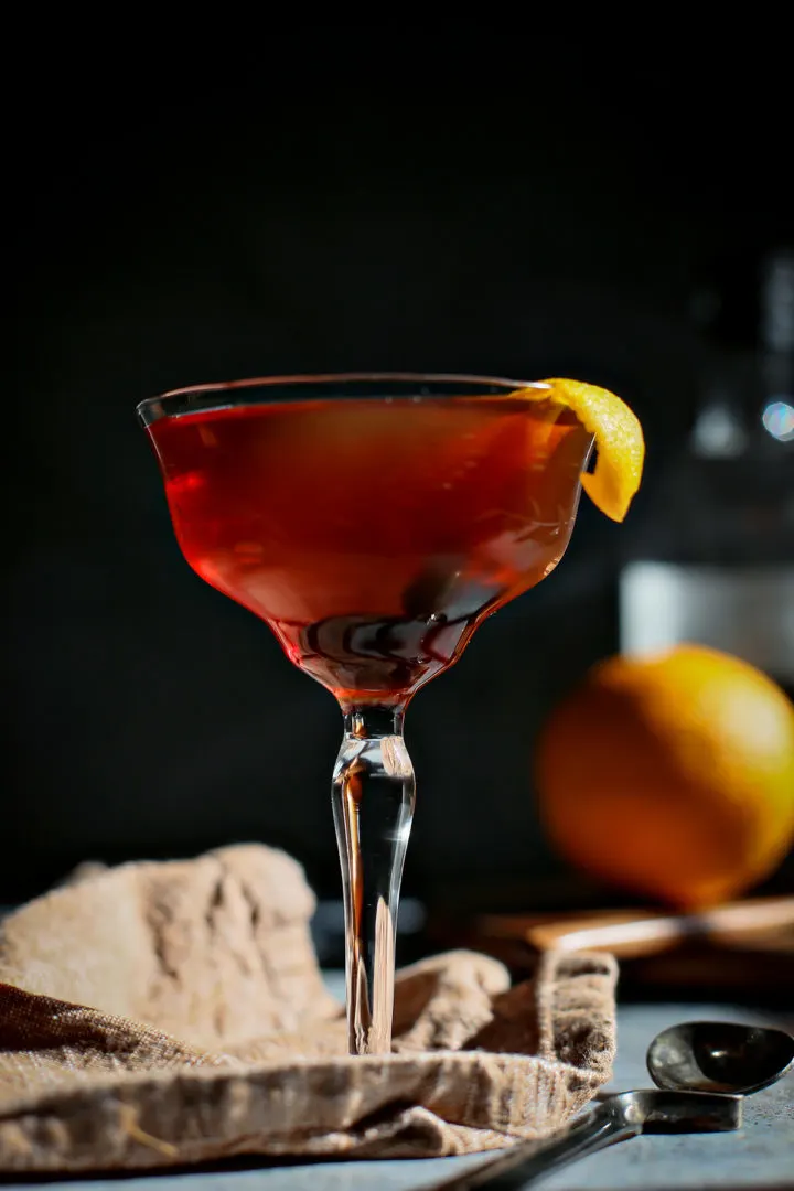 close up photo of a black manhattan in a coupe glass