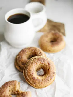photo of cinnamon donuts with a mug of coffee on a wooden cutting board