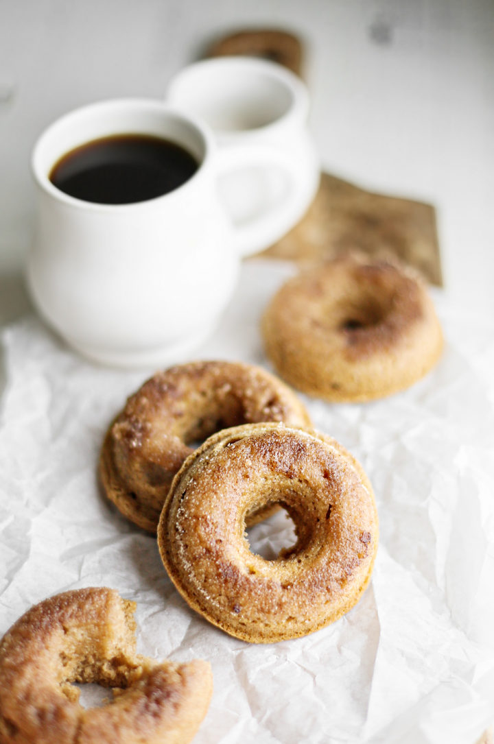 a photo of baked cinnamon sugar donuts next to a mug of coffee