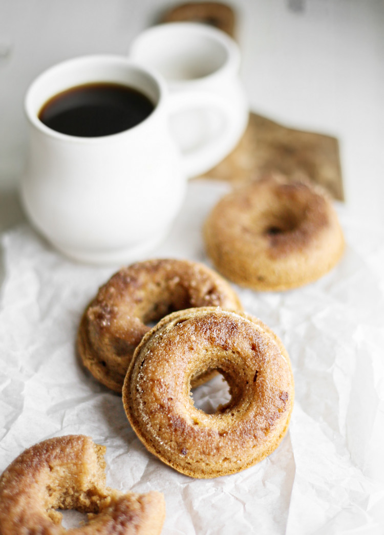 photo of cinnamon donuts with a mug of coffee on a wooden cutting board