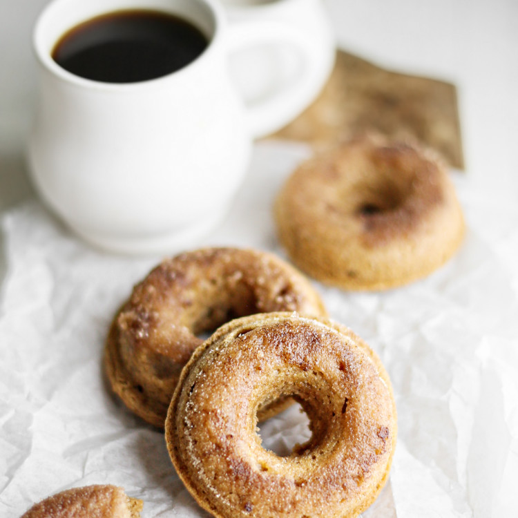 photo of cinnamon donuts with a mug of coffee on a wooden cutting board