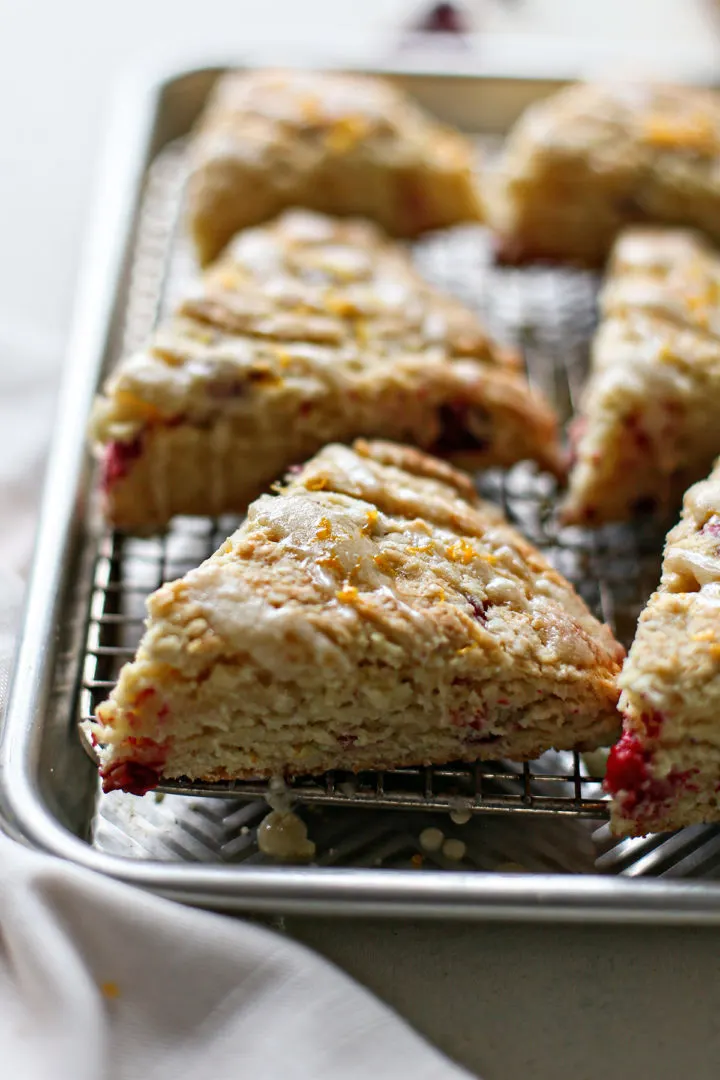 photo of cranberry scones glazed with sweet orange glaze on a baking sheet with wire rack