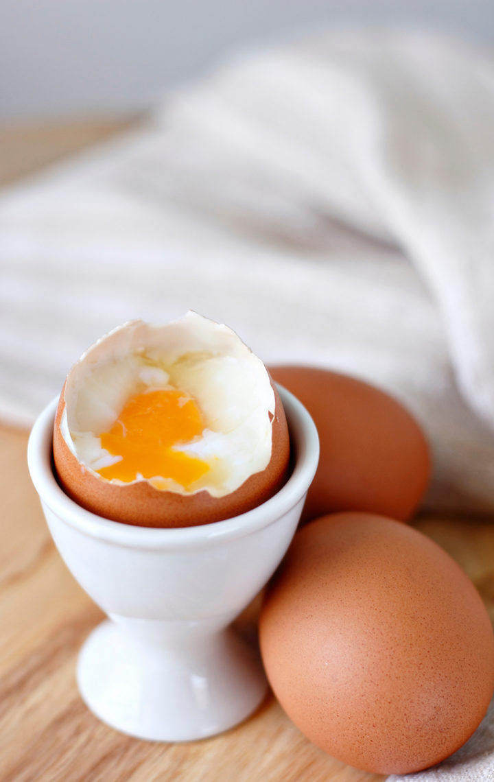 photo of a soft cooked egg cooked in the microwave in a white egg cup