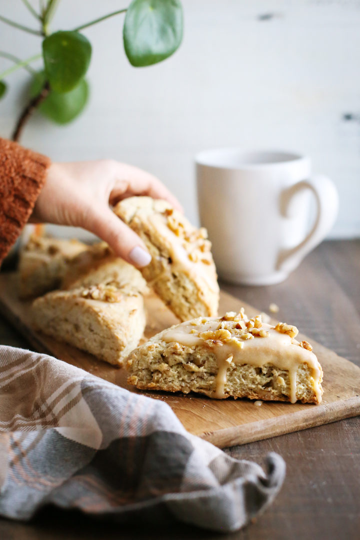 woman picking up a maple glazed scone