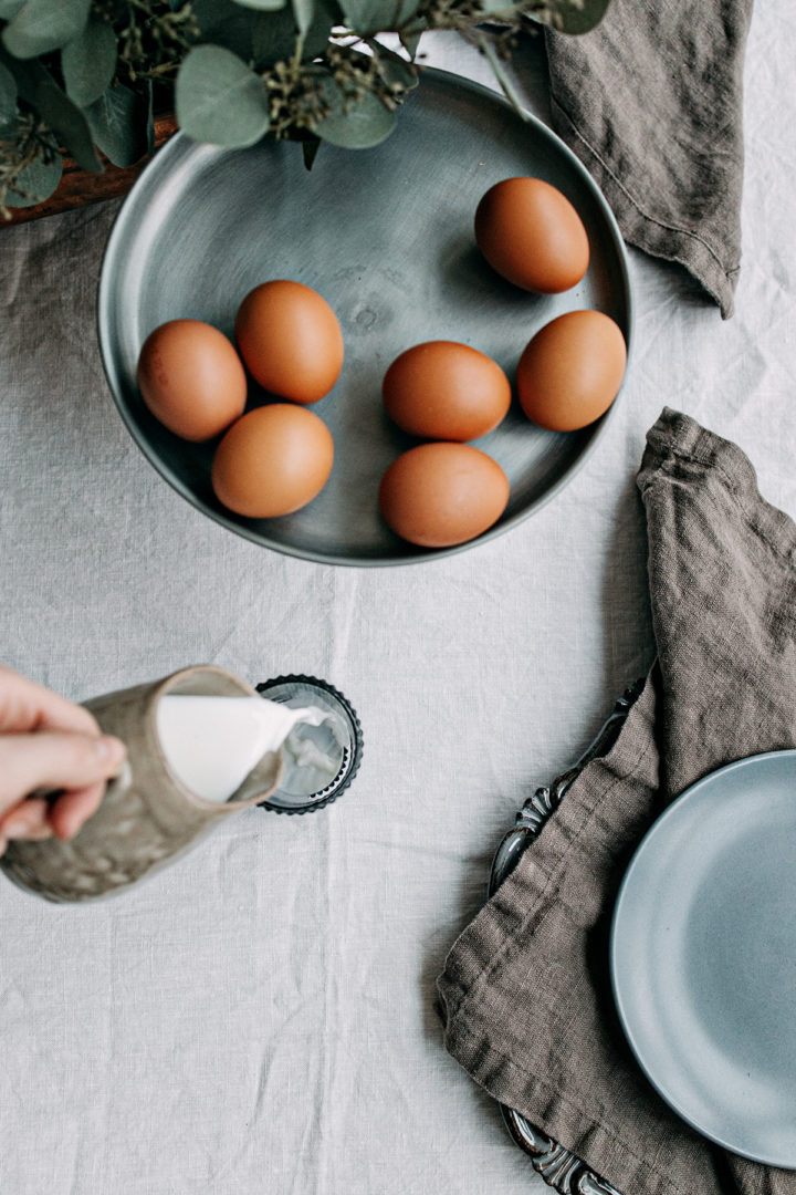 photo of a table set with microwave hard boiled eggs on a dark plate with napkins and tablecloth