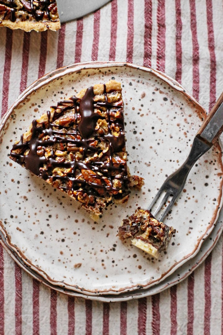 photo of a slice of chocolate pecan tartlets on a plate with a fork