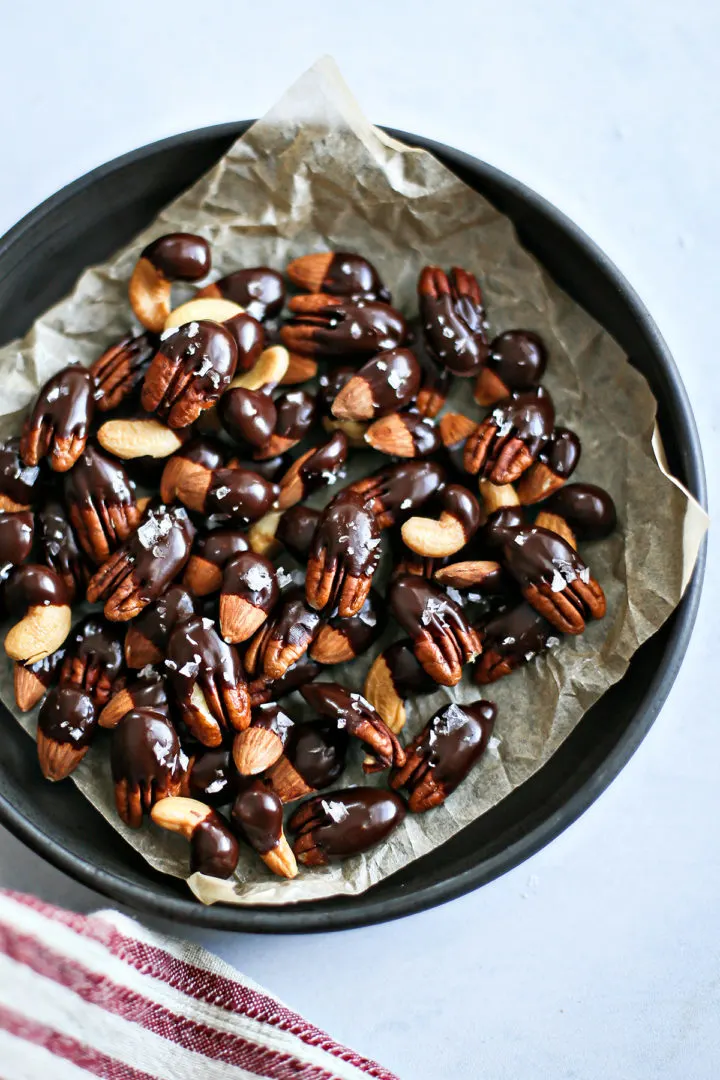 overhead photo of a bowl of chocolate dipped nuts on a counter