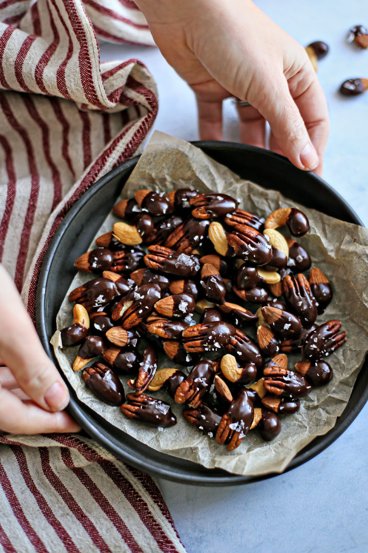 woman holding a bowl of chocolate dipped nuts