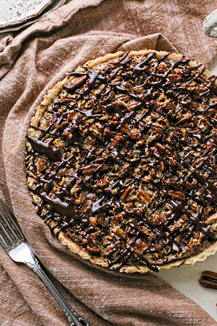 photo of a chocolate pecan tart topped with chocolate ganache