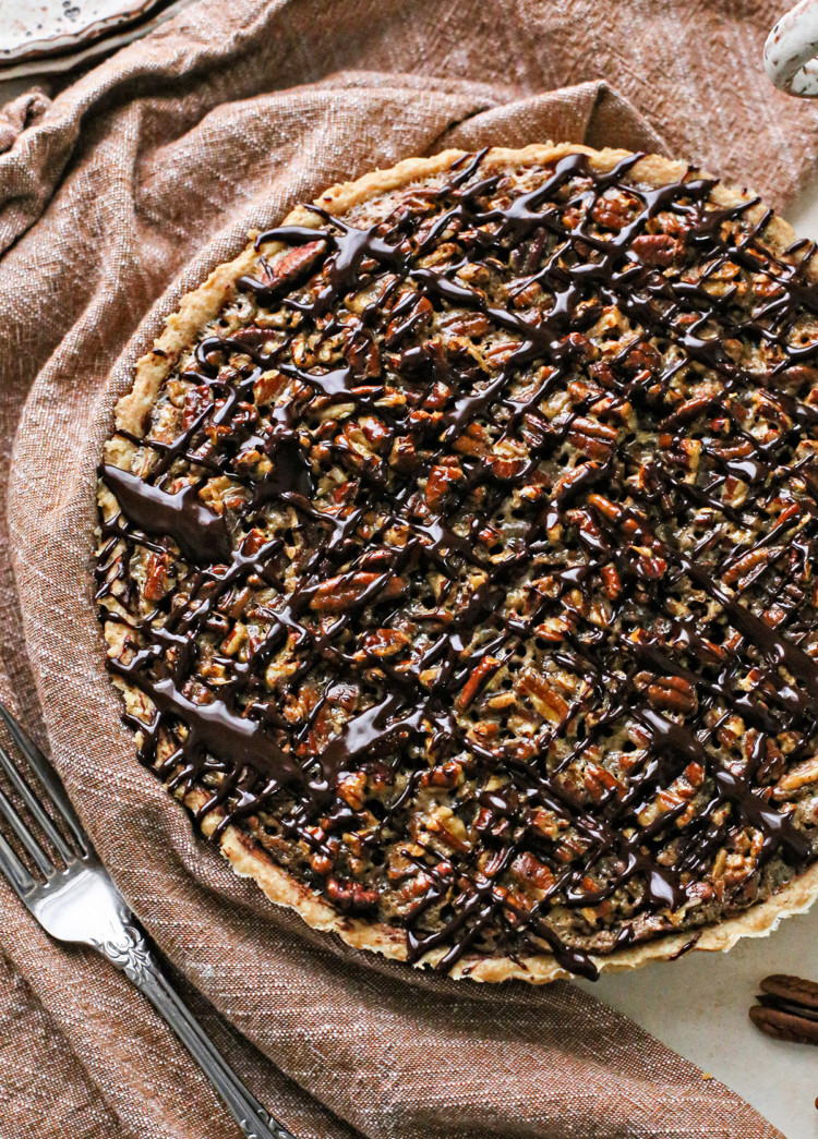 photo of a chocolate pecan tart recipe drizzled in chocolate ganache