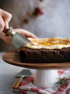 woman slicing a chocolate gingerbread cake