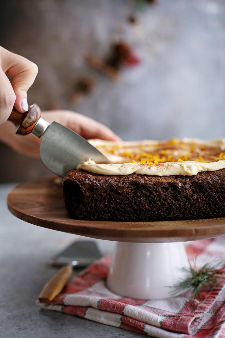 woman slicing a chocolate gingerbread cake