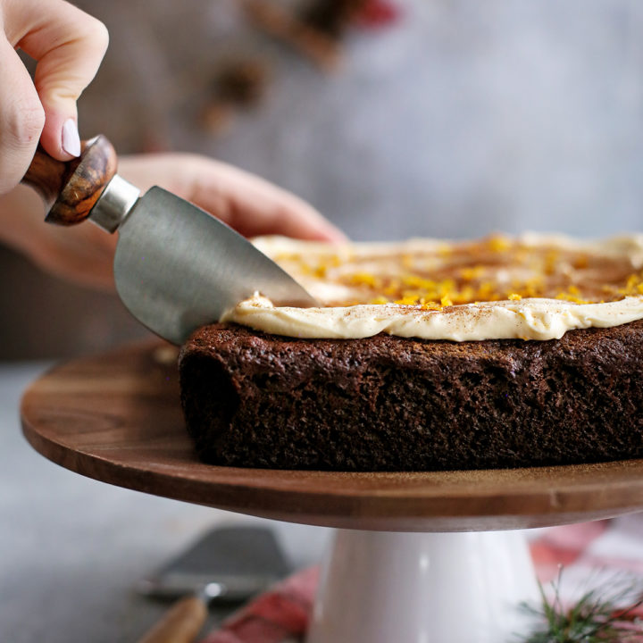 woman slicing a chocolate gingerbread cake