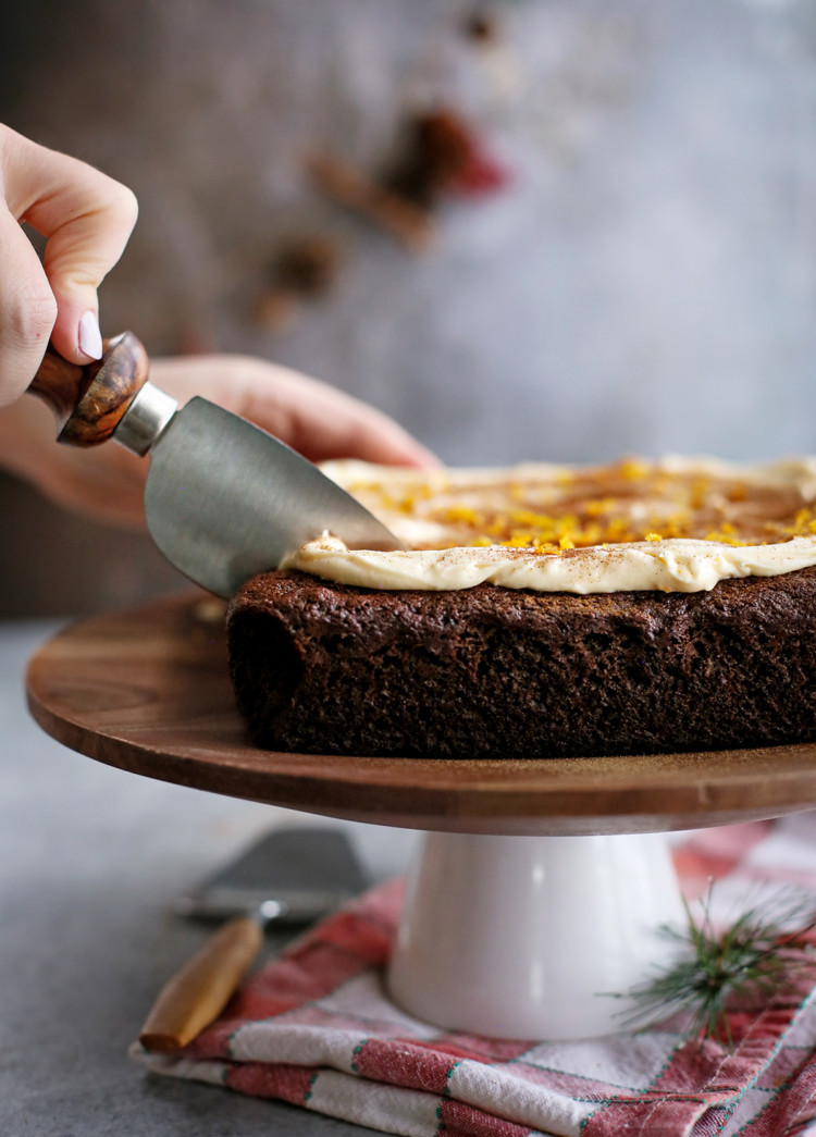 woman slicing a chocolate gingerbread cake