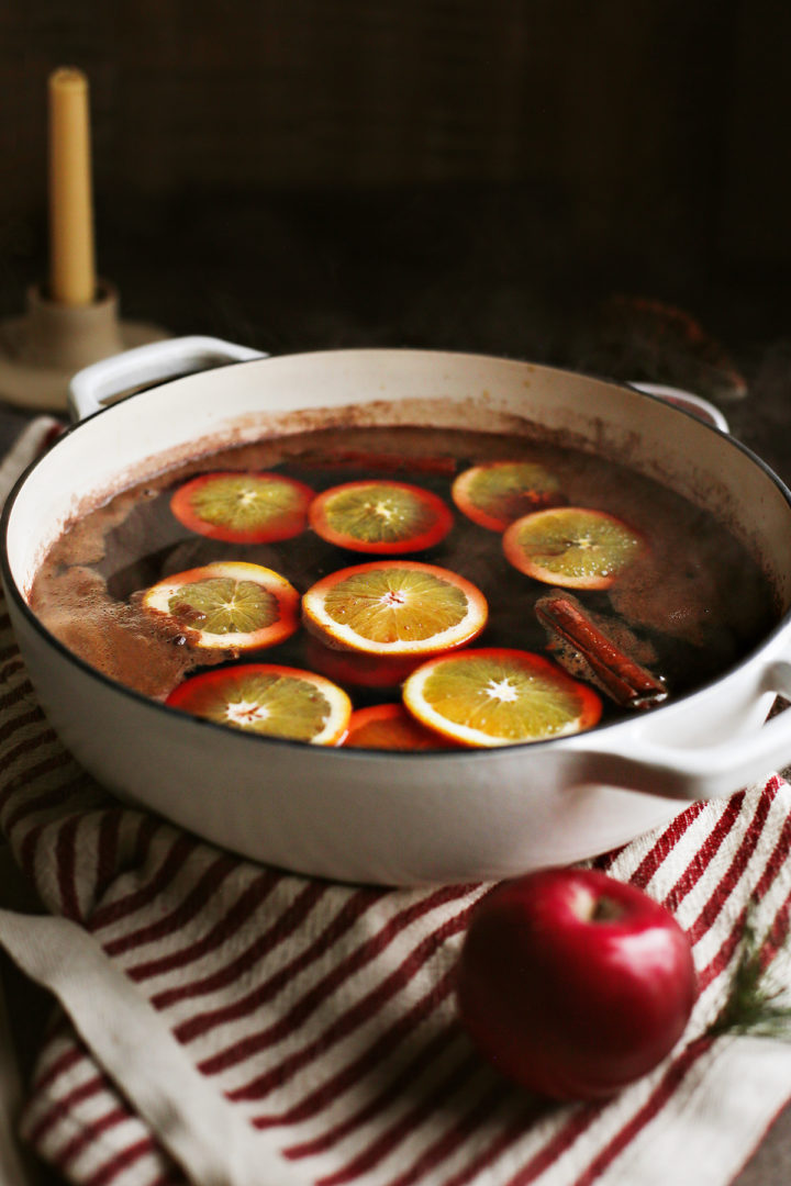 a cast iron pot full of spiced apple cider with orange slices