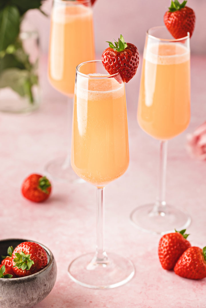 photo of 3 champagne flutes of strawberry mimosas