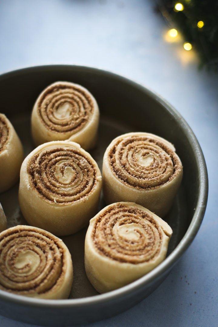 photo of rolled cinnamon rolls rising in a pan before baking