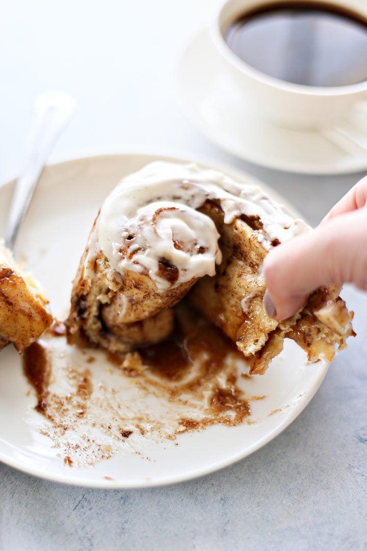 photo of a woman eating the best ever cinnamon rolls