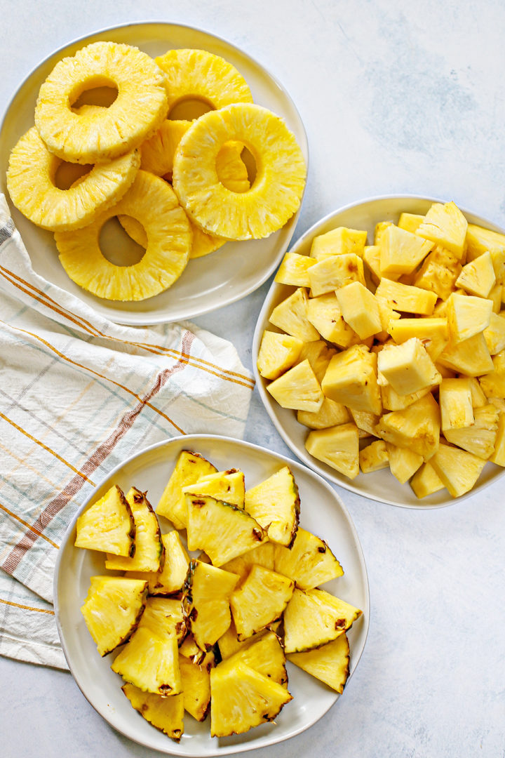 different ways that pineapple can be cut - a plate of pineapple wedges, a plate of pineapple cubes, and a plate of pineapple rings