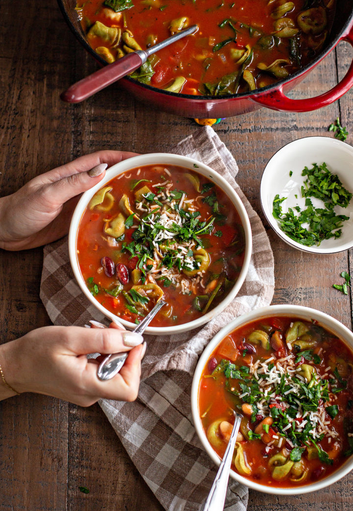 photo of a woman eating a bowl of cheese tortellini soup