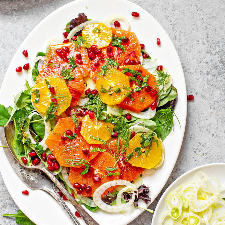 fennel salad on a white platter with oranges and pomegranate