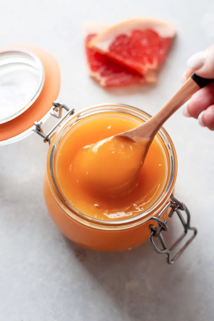 grapefruitcurd photo of grapefruit curd in a jar with a spoon
