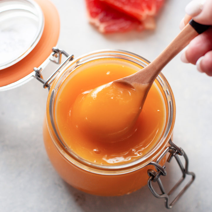 photo of grapefruit curd in a jar with a spoon