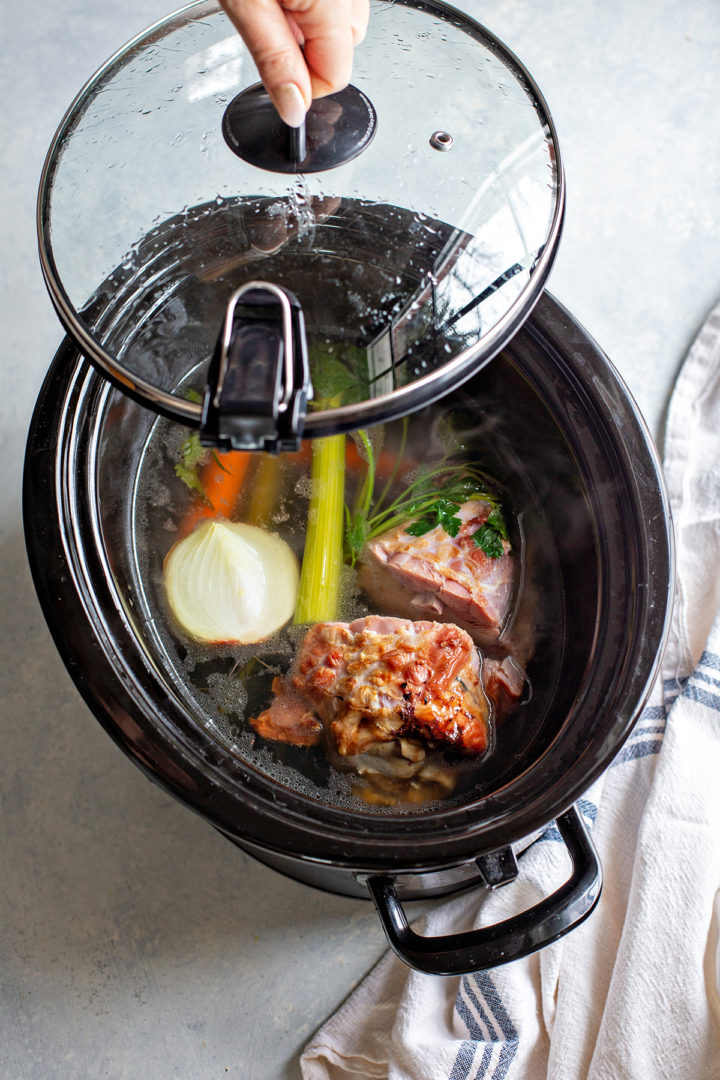 photo of homemade ham broth in a crockpot for this slow cooker potato and ham soup
