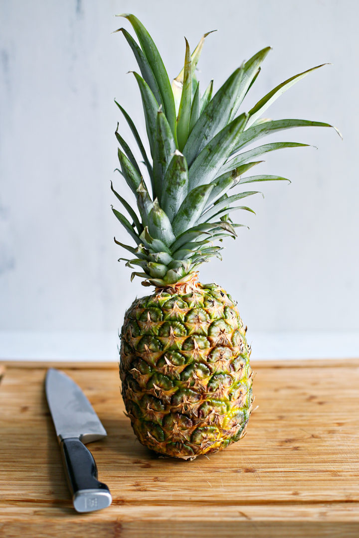 fresh pineapple and tools needed for cutting pineapple