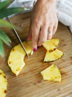 woman showing how to cut a pineapple