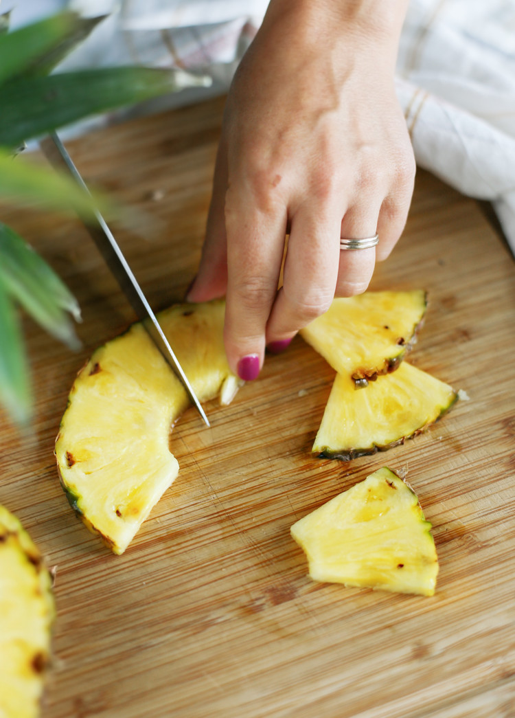 woman showing how to cut a pineapple