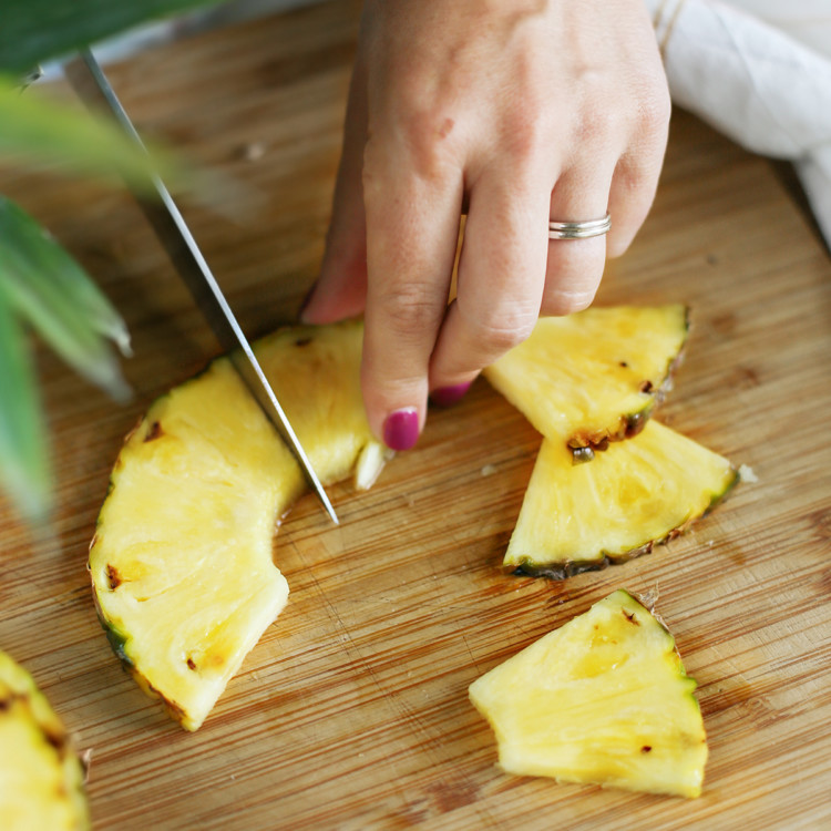 woman showing how to cut a pineapple