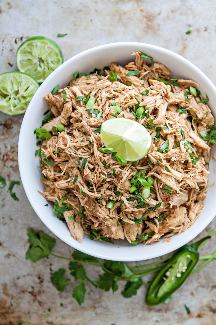 overhead photo of a white bowl with shredded chicken in it