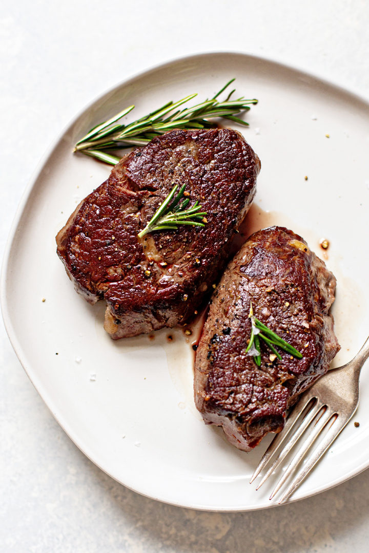 sous vide filet mignon on a white plate resting after searing