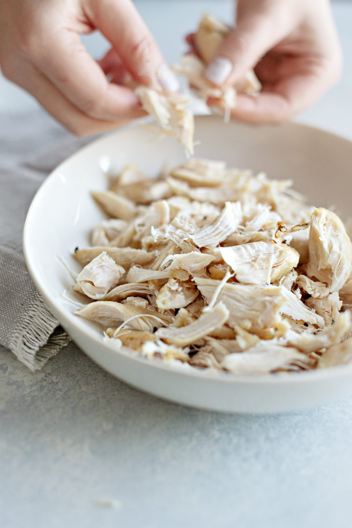 photo of a woman showing how to make shredded chicken using her hands