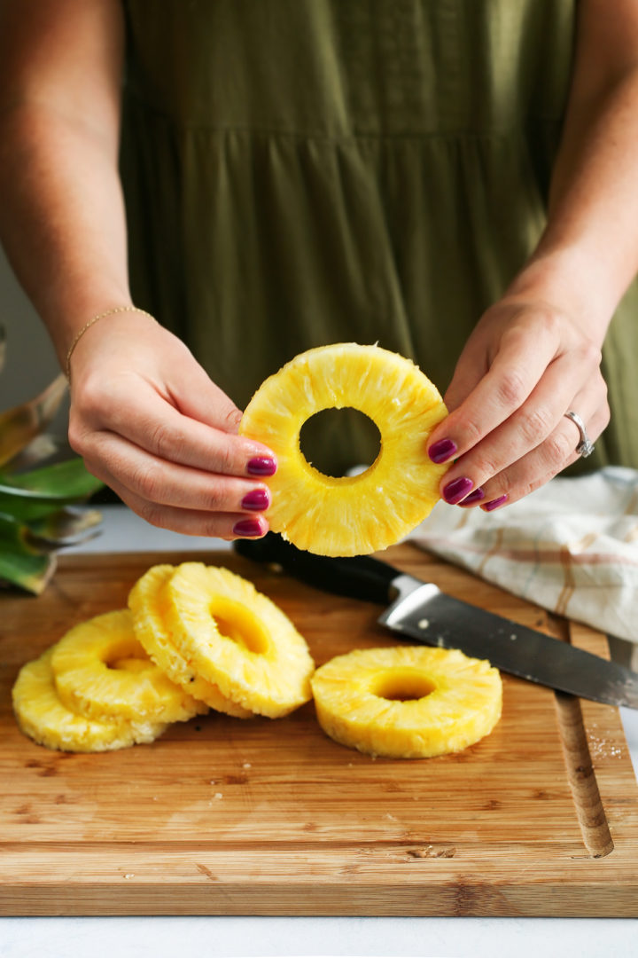 woman showing how to cut a pineapple in rings