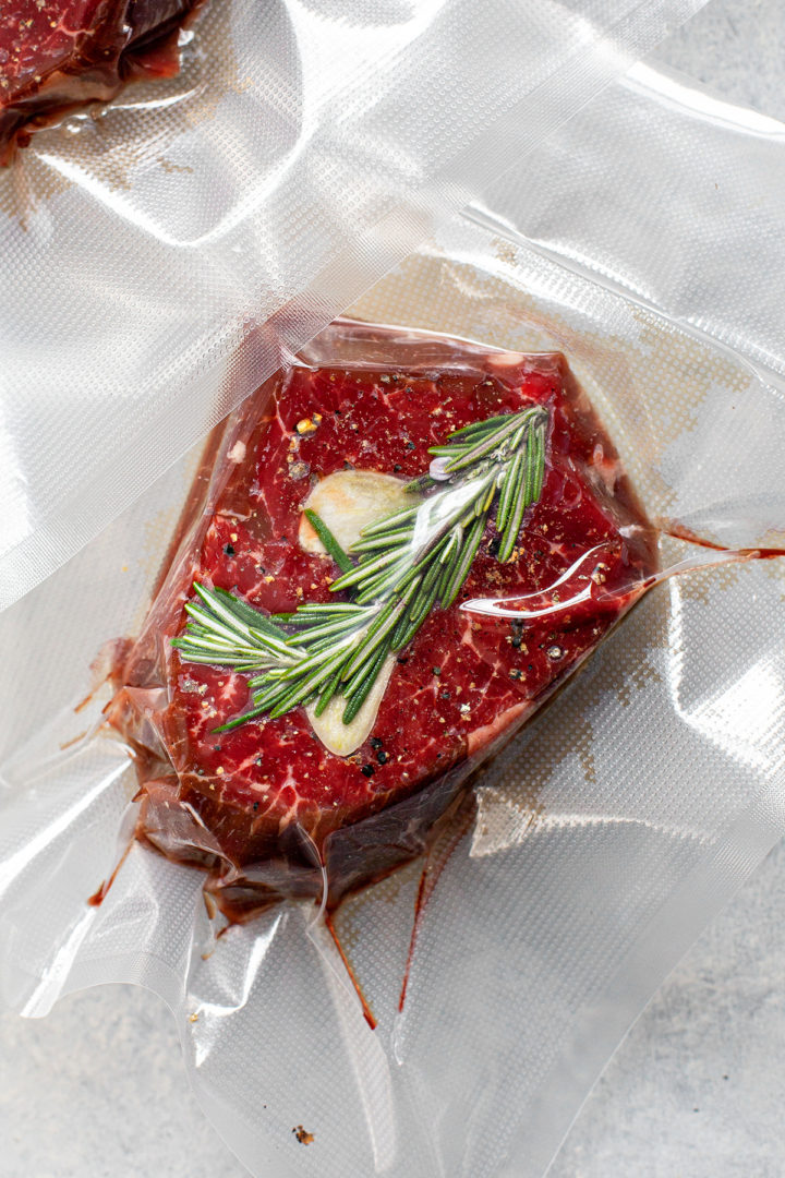 filet mignon in a vacuum seal bag with rosemary and garlic before cooking in sous vide