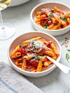 bowls of this pasta arrabiata recipe with parmesan on top