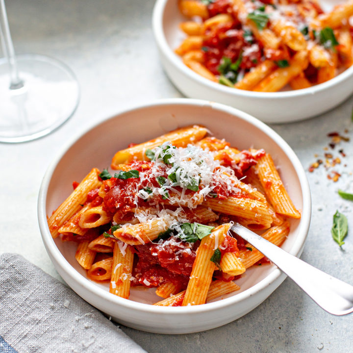 bowls of this pasta arrabiata recipe with parmesan on top