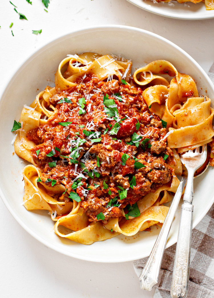 photo of bolongese sauce on pasta in a white bowl