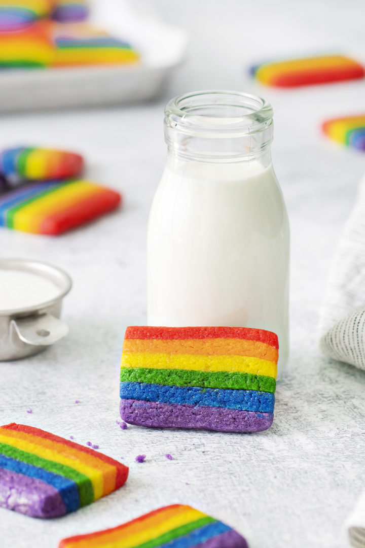 st. patrick's day rainbow cookie next to a cup of milk