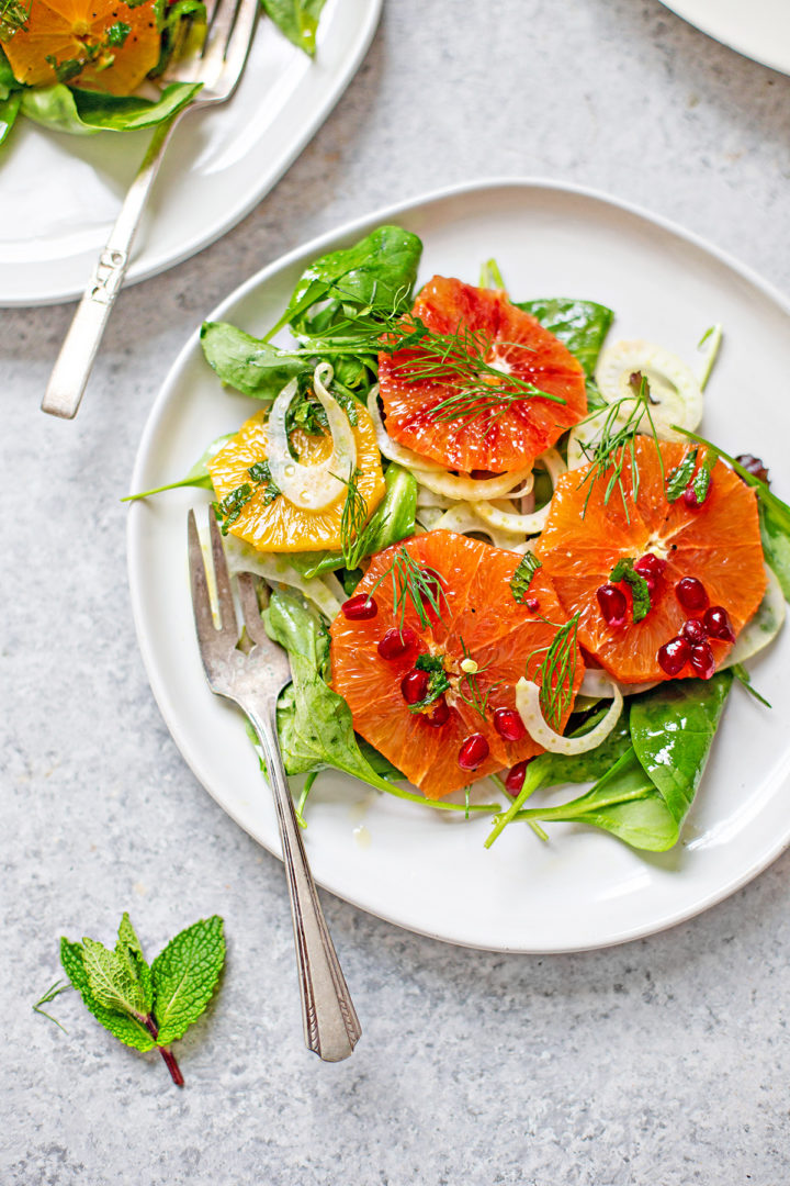 overhead photo of a white plate with fennel and orange salad and a salad fork