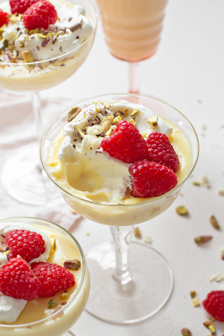 a glass dessert dish of white chocolate pudding with a bite taken out