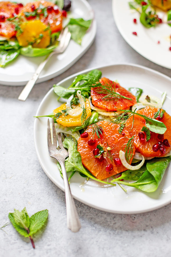 close up photo of plates set on a table with fennel orange salad on them