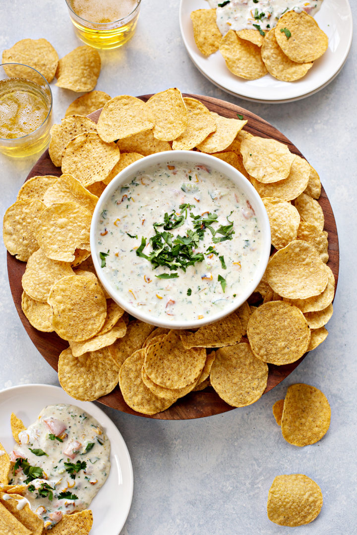 photo of a bowl of queso blanco with chips and beer