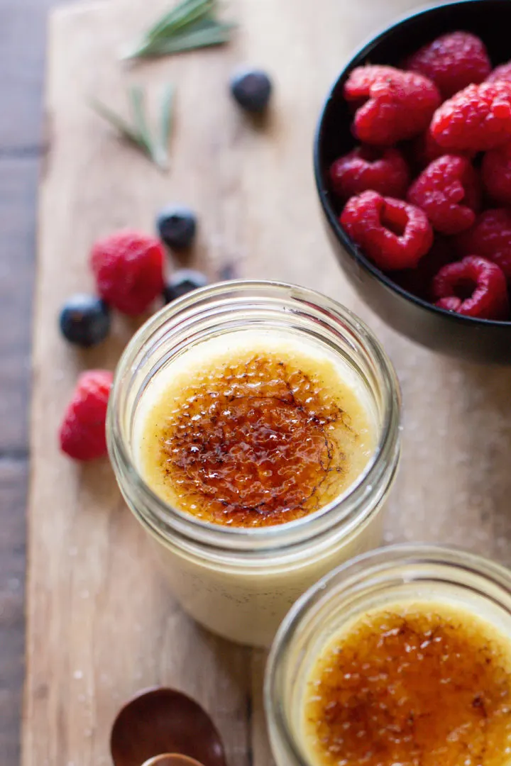 photo of a cutting board with fresh berries and a jar of vanilla bean crème brûlée that has been cooked in a sous vide 