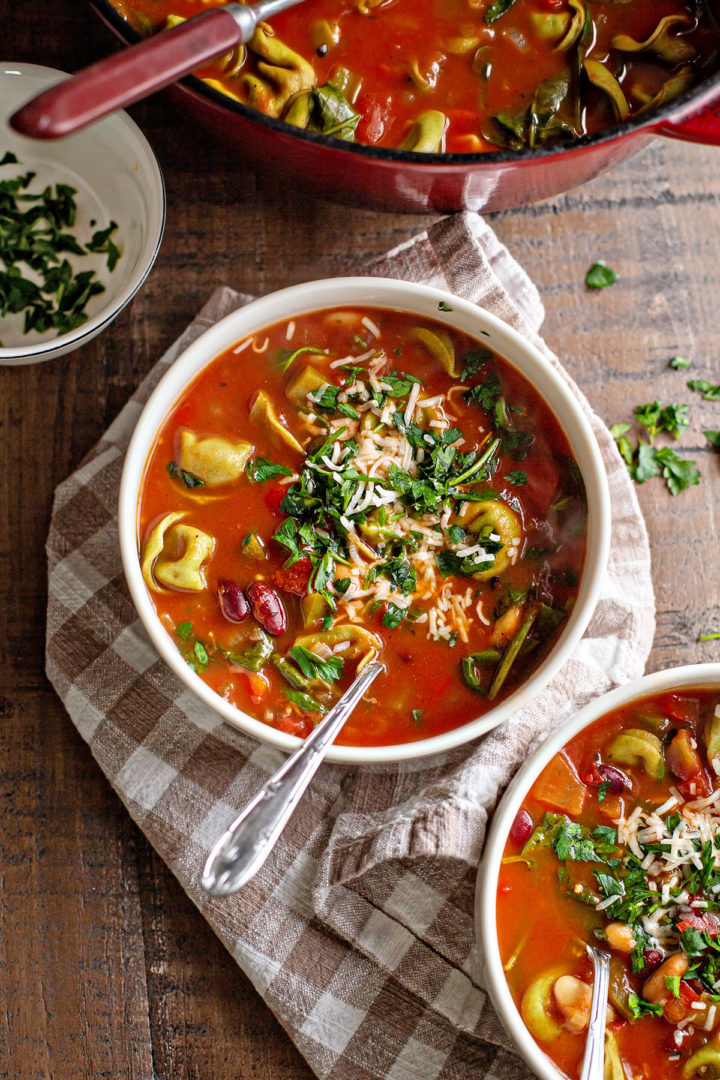 photo of a table set with bowls of tortellini soup with spinach