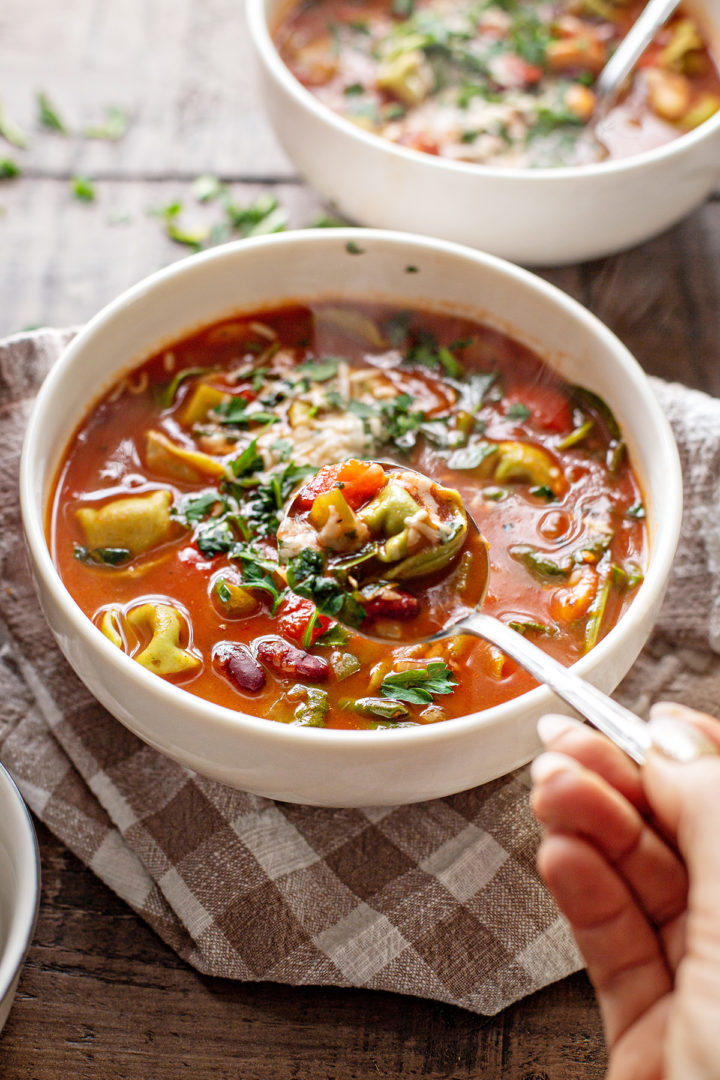 photo of a woman eating spinach tortellini soup