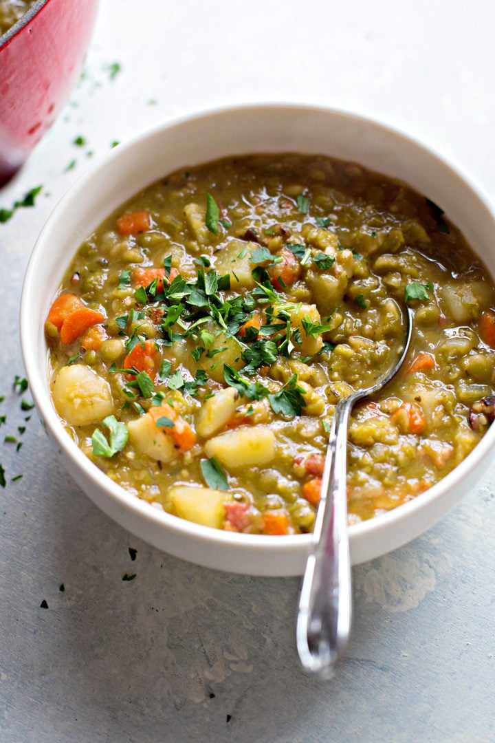 a serving of split pea soup recipe with bacon in a white bowl with a spoon